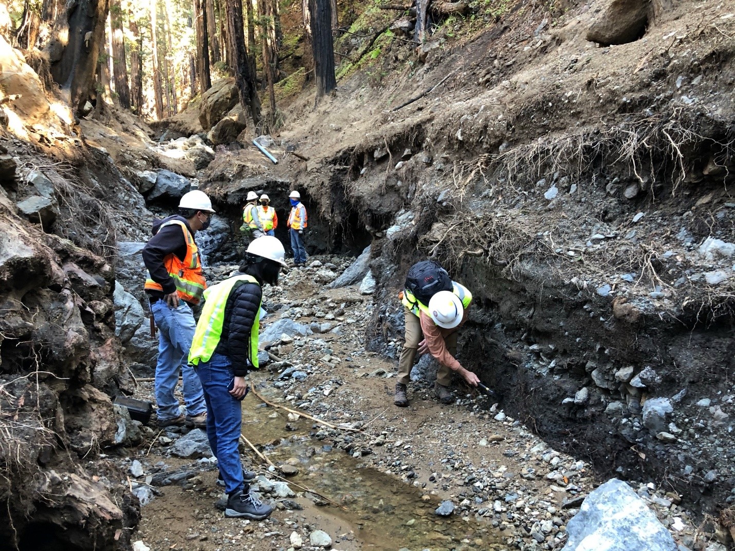Reconnaissance team inspecting a portion of the scoured area by the debris flow that reached Highway 1.